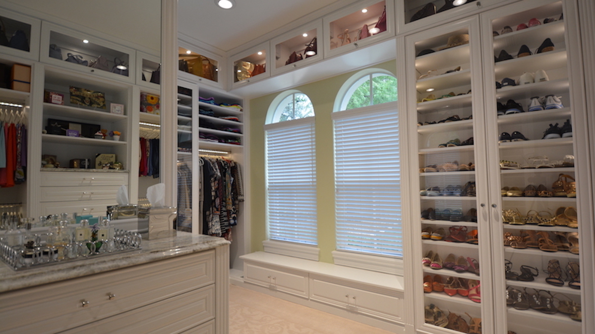 A custom closet featuring built-in storage and windows.