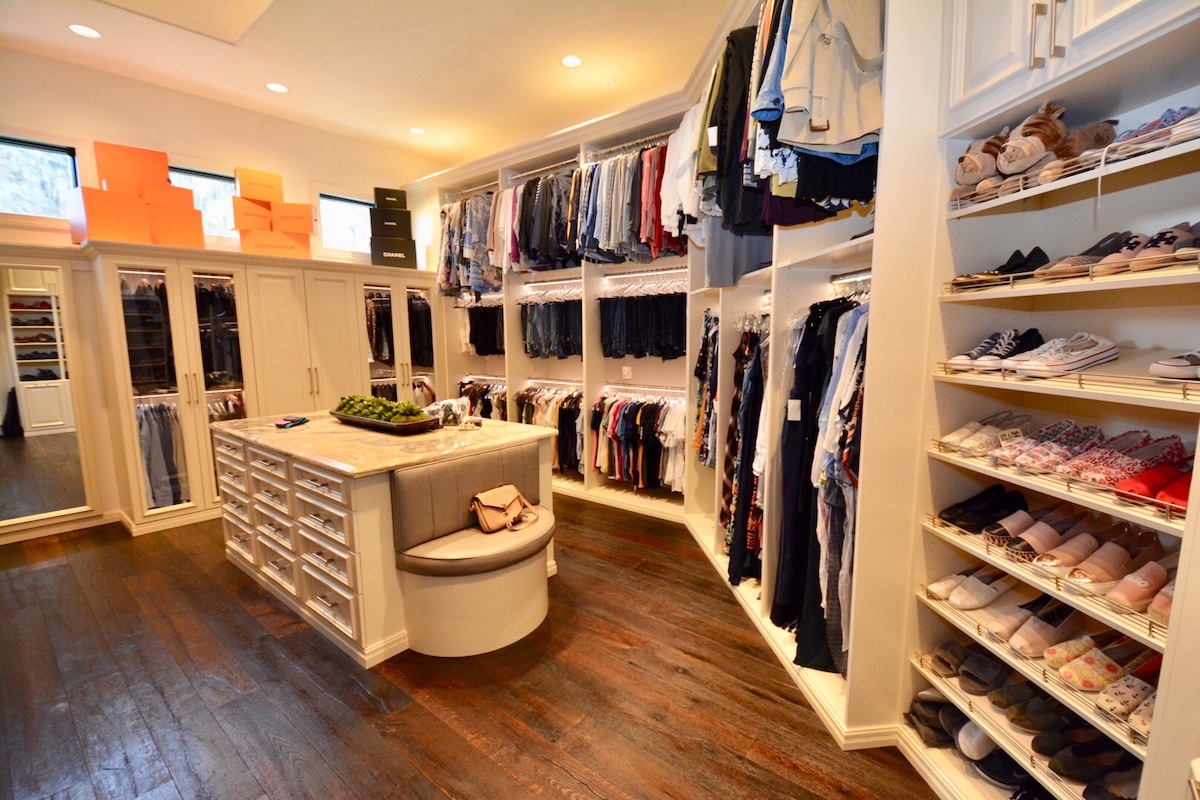 A spacious walk-in closet with attractive cabinetry and flooring.