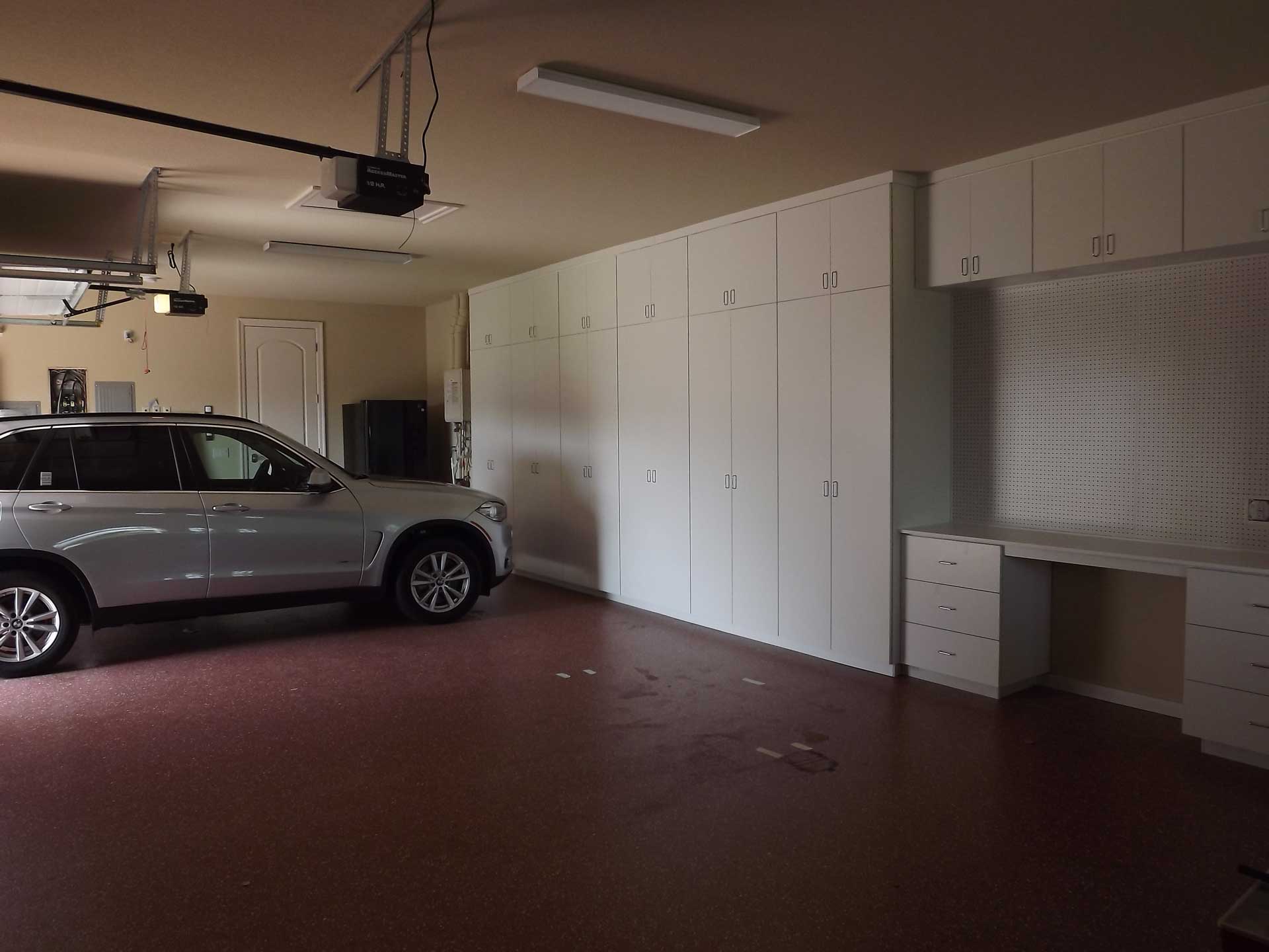 An organized garage, with a parked car and custom storage system.